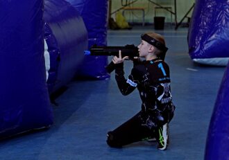 Мальчик в синей команде прицеливается из оружия LASERWAR.